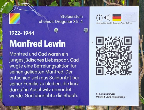 Gedenktafel mit Text zu Manfred Lewin, einem jungen jüdischen Liebespaar, mit QR-Code für Audio-Beitrag und Regenbogenflagge