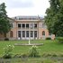 Blick auf die klassizistische Villa Harteneck mit Garten und Springbrunnen im Vordergrund.