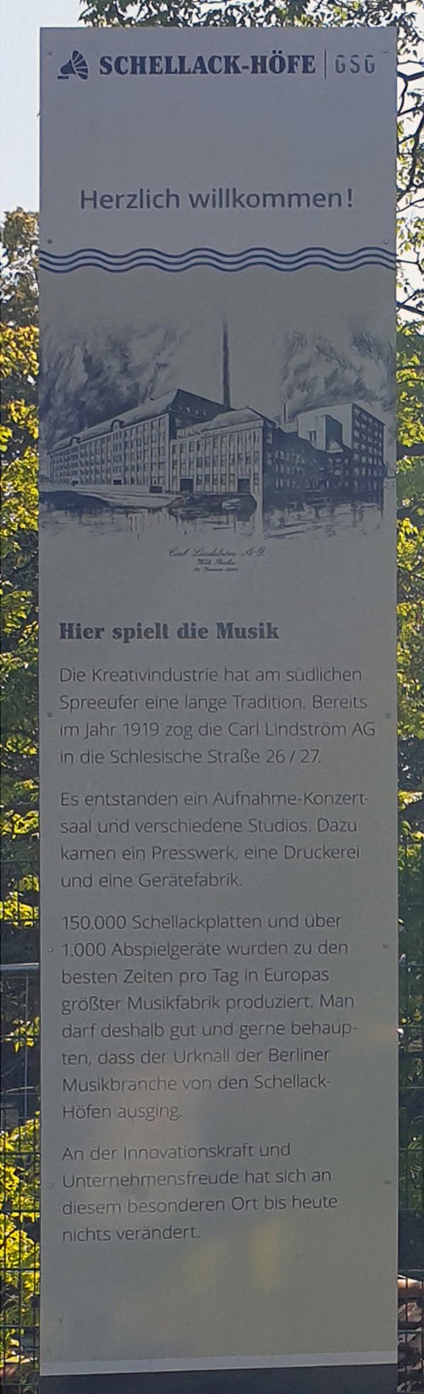 Eine weiße Infostele mit blauem Text über die Schellack-Höfe und einer Zeichnung der Carl Lindström AG.