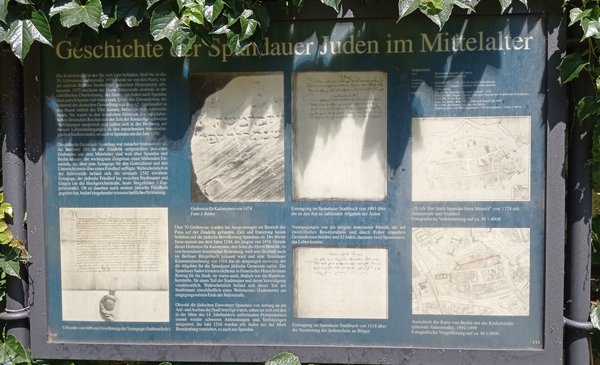 Blaue Infotafel mit Text und Bildern von historischen Objekten.