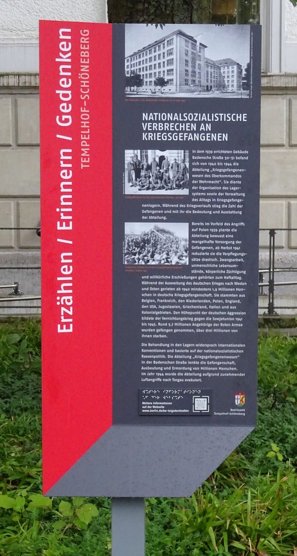 Gedenkstele mit Text, historischen Bildern des Gebäudes und von Kriegsgefangenen und taktiler Schrift für die NS-Verbrechen an Kriegsgefangenen.