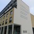 Fassadenbeschriftung mit Text in Großbuchstaben über Sprachzweifel und guten Wünschen in Deutsch und Englisch
