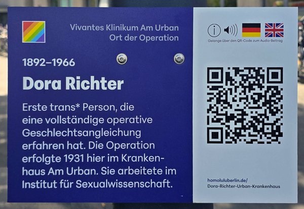 Gedenktafel mit Text zu Dora Richter als erster trans* Person mit vollständiger operativer Geschlechtsangleichung 1931 im Krankenhaus Am Urban und QR-Code für Audio-Beitrag.