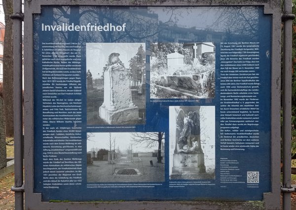 Informationstafel zum Invalidenfriedhof mit mehreren historischen Schwarz-weiß-Fotografien von Grabsteinen und dem Friedhofsgelände
